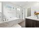 Luxurious bathroom with a soaking tub, glass-enclosed shower, and double vanity sinks at 1376 Snowberry Ln, Louisville, CO 80027