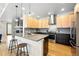 Stylish kitchen with stainless steel appliances, a breakfast bar, and a view of the fireplace at 1376 Snowberry Ln, Louisville, CO 80027