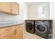 Well-equipped laundry room with modern washer and dryer, ample counter space, and storage cabinets at 1376 Snowberry Ln, Louisville, CO 80027