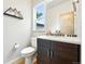 Modern powder room featuring sleek vanity with stone countertop and stylish mirror at 1376 Snowberry Ln, Louisville, CO 80027