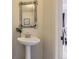 Charming powder room featuring a pedestal sink with rustic wood framed mirror at 7822 S Kittredge Cir, Englewood, CO 80112