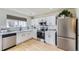 Updated kitchen with white cabinetry, stainless steel appliances, and subway tile backsplash at 7822 S Kittredge Cir, Englewood, CO 80112