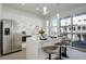 Modern kitchen with white cabinets, stainless steel appliances, and island seating with sliding glass doors to the balcony at 3500 S Corona St # 205, Englewood, CO 80113