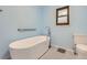 Bright bathroom with a modern white freestanding tub, toilet and light blue painted walls at 8075 S Harrison Way, Centennial, CO 80122
