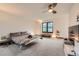 Bright bedroom with a large window, carpeted floors, ceiling fan, and a neutral color palette at 8075 S Harrison Way, Centennial, CO 80122