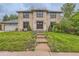 Inviting two-story brick home featuring a landscaped front yard and charming architectural details at 8075 S Harrison Way, Centennial, CO 80122