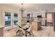 Bright kitchen with stainless appliances, an island, light grey cabinets, and a glass-top table and chairs at 8075 S Harrison Way, Centennial, CO 80122