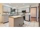 Well-lit kitchen with center island, gray cabinets, stainless steel appliances, and tile flooring at 8075 S Harrison Way, Centennial, CO 80122