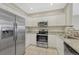 Well-lit kitchen boasting stainless steel appliances, granite counters, and ample white cabinetry at 9568 W San Juan Cir # 203, Littleton, CO 80128