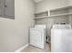 Practical laundry room with washer, dryer, and open shelving, optimizing space and convenience at 9568 W San Juan Cir # 203, Littleton, CO 80128
