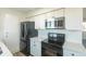 Modern kitchen with white cabinets, quartz countertops, and stainless steel appliances at 9318 W 100Th Cir, Broomfield, CO 80021