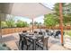 Inviting backyard patio with a shade cover, dining table, and a comfortable seating area for relaxation and entertaining at 2027 S Welch Cir, Lakewood, CO 80228