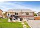 Spacious backyard with a stone-accented patio, shade cover, lush lawn, and well-kept landscaping for outdoor enjoyment at 2027 S Welch Cir, Lakewood, CO 80228
