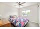 Cozy bedroom featuring a stylish ceiling fan, natural light, and a comfortable bed with colorful patterned bedding at 2027 S Welch Cir, Lakewood, CO 80228