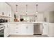 Modern kitchen with white cabinetry, stainless steel appliances, and stylish pendant lighting at 2027 S Welch Cir, Lakewood, CO 80228