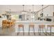 Open concept kitchen with stainless appliances, quartz counters and island with seating, and lots of natural light at 2027 S Welch Cir, Lakewood, CO 80228