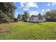 Large green backyard featuring mature trees and a storage shed at 280 Ammons St, Lakewood, CO 80226