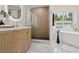 Modern bathroom with a glass-enclosed shower, wooden vanity, and a freestanding bathtub at 280 Ammons St, Lakewood, CO 80226