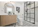 Elegant bathroom featuring a glass-enclosed shower, a vanity, decorative mirror, and patterned tile floor at 280 Ammons St, Lakewood, CO 80226