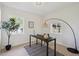 Bright home office featuring a large window, hardwood floors, and a stylish black desk with modern decor at 280 Ammons St, Lakewood, CO 80226