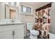 Traditional bathroom featuring a vanity, toilet, and shower/tub combo with patterned curtain at 3930 W Kentucky Ave, Denver, CO 80219