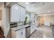 Bright kitchen featuring white cabinets, stainless steel appliances, and granite countertops at 3930 W Kentucky Ave, Denver, CO 80219