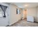 Cozy room featuring wood-look floors, and a white door leading to the outdoors at 3930 W Kentucky Ave, Denver, CO 80219