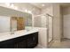 Bright bathroom features a double sink vanity, large mirror, a tile surround shower and a closet organizer at 655 Stonebridge Dr, Longmont, CO 80503