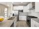 Spacious kitchen featuring stainless steel appliances, white cabinetry, and a granite island with a sink at 655 Stonebridge Dr, Longmont, CO 80503