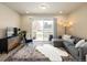 Comfortable living room with sliding glass doors, a large patterned rug, and plenty of natural light at 655 Stonebridge Dr, Longmont, CO 80503