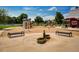 Community playground with multiple play structures set in a sand area, surrounded by benches and open space at 655 Stonebridge Dr, Longmont, CO 80503