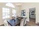 Modern dining room with a large table and view into the kitchen at 10187 Lynx Ln, Littleton, CO 80125