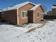 Back of single-story home with siding, snow-covered lawn, a patio, and visible utilities at 25858 E Bayaud Ave, Aurora, CO 80018