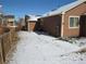 Home exterior shows a yard with brown siding, a wood fence, and some snow cover at 25858 E Bayaud Ave, Aurora, CO 80018