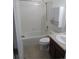 Bathroom with tub, shower, and vanity, featuring white tile and neutral finishes at 25858 E Bayaud Ave, Aurora, CO 80018