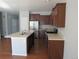 View of kitchen featuring stainless steel appliances, island sink, and dark wood cabinets at 25858 E Bayaud Ave, Aurora, CO 80018