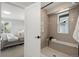 Modern bathroom featuring a tiled shower with built-in bench and a view of the bedroom at 4020 Upham St, Wheat Ridge, CO 80033