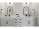 Elegant bathroom with double vanity, modern lighting, and arched mirrors, creating a luxurious and functional space at 4020 Upham St, Wheat Ridge, CO 80033