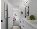 Well-lit bathroom featuring double vanity with sleek fixtures, arched mirror, and view into a bedroom, creating a relaxing space at 4020 Upham St, Wheat Ridge, CO 80033