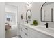 Stylish bathroom featuring double vanity, black hardware, and modern mirrors, with a bedroom view at 4020 Upham St, Wheat Ridge, CO 80033