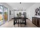Bright dining area leading to a modern kitchen with white cabinets, an island, and stainless steel appliances at 4020 Upham St, Wheat Ridge, CO 80033