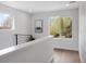 Well-lit hallway with a modern railing, hardwood floors, and a view of the outdoors at 4020 Upham St, Wheat Ridge, CO 80033