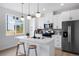 Modern kitchen with white cabinets, stainless steel appliances, an island with seating and pendant lighting at 4020 Upham St, Wheat Ridge, CO 80033