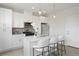 Kitchen with white cabinets, an island with breakfast bar, and modern pendant lighting at 4020 Upham St, Wheat Ridge, CO 80033