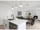 Open-concept kitchen with white cabinets, stainless steel appliances, and a view of dining area at 4020 Upham St, Wheat Ridge, CO 80033