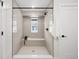Modern tiled shower with a built-in bench, sleek fixtures, and bright natural light at 4020 Upham St, Wheat Ridge, CO 80033