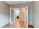 The bonus room has hardwood floors, double doors, and a view to the bathroom at 13744 Columbine St, Thornton, CO 80602
