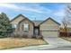 Charming single-story home featuring stone and siding accents, a two-car garage, and well-maintained landscaping at 13744 Columbine St, Thornton, CO 80602