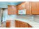 Well-lit kitchen features wooden cabinets, white microwave, and tile countertops at 13744 Columbine St, Thornton, CO 80602