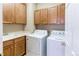 Functional laundry room featuring wooden cabinets, white washer and dryer, and a utility sink at 13744 Columbine St, Thornton, CO 80602